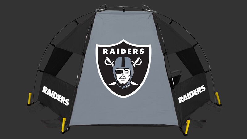 A Las Vegas Raiders sideline sun shelter set up on a beach with a chair, football, cooler and water bottle - SKU: 00961072111