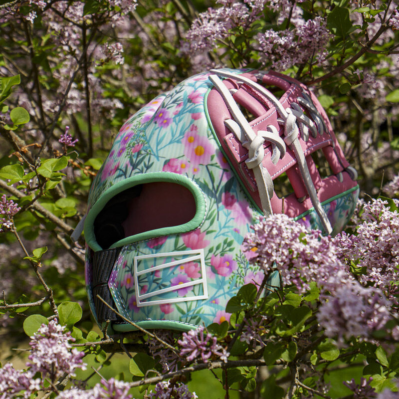 Picture of the back of a Rawlings Race Day REV1X infield glove in a flower bush