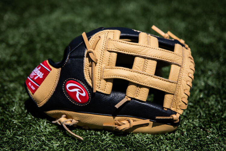 A Prodigy H-web youth outfield glove lying on a field - SKU: P120CBH