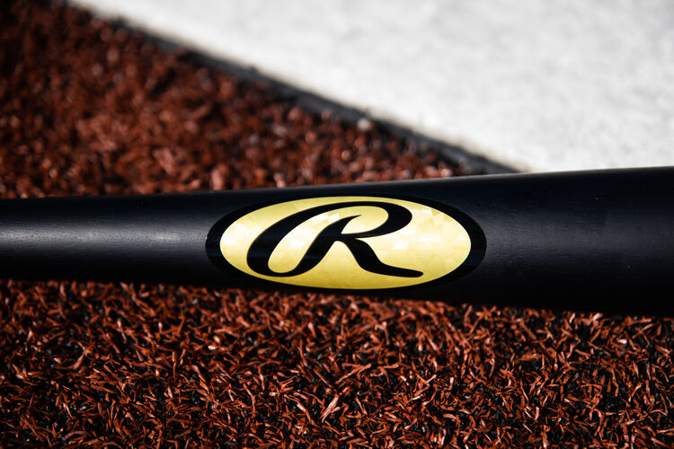 Gold foil Rawlings Oval-R on a black Khris Davis bat lying next to home plate - SKU: KD2PL