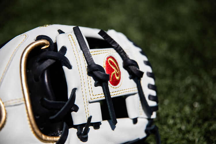 White I-web on and 11.5-Inch Encore infield glove lying on a field - SKU: EC1150-2BW
