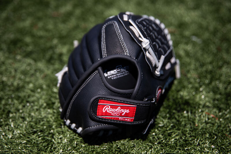 Rawlings patch on a wrist strap of a Rawlings RSB recreational glove lying on a field - SKU: RSB125GB