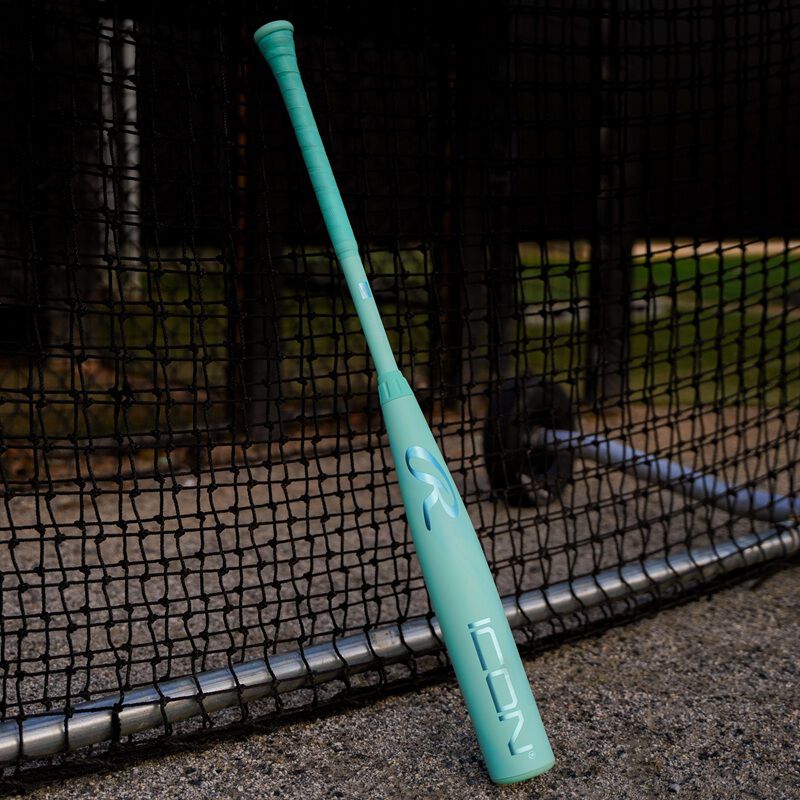A 2026 Rawlings Icon BBCOR bat leaning against a batting cage