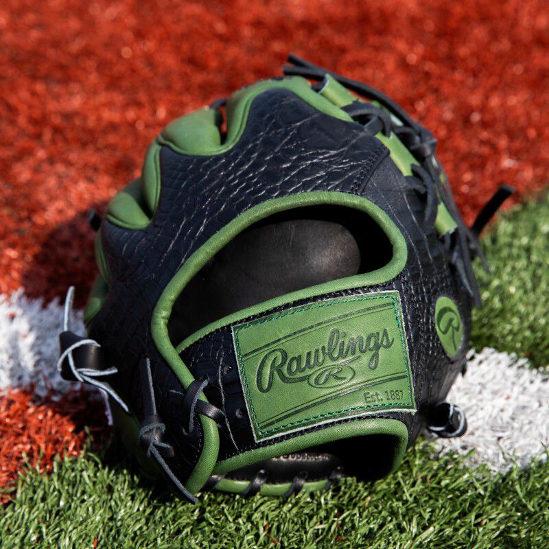 Military green leather Rawlings patch on the wrist of a Heart of the Hide ColorSync 8.0 infield glove on a field