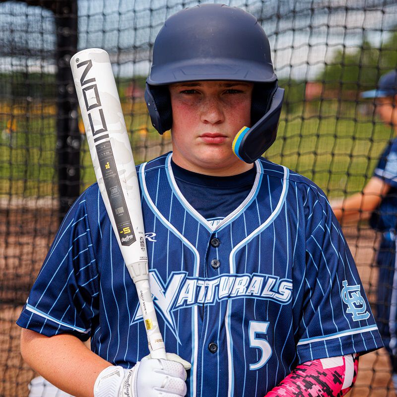 Picture of a baseball player holding a 2025 Icon USSSA bat on his shoulder