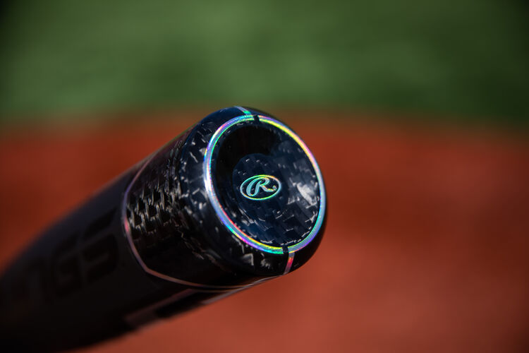 Carbon fiber end cap on a USA -10 Velo ACP bat with a field in the background - SKU: USZV10