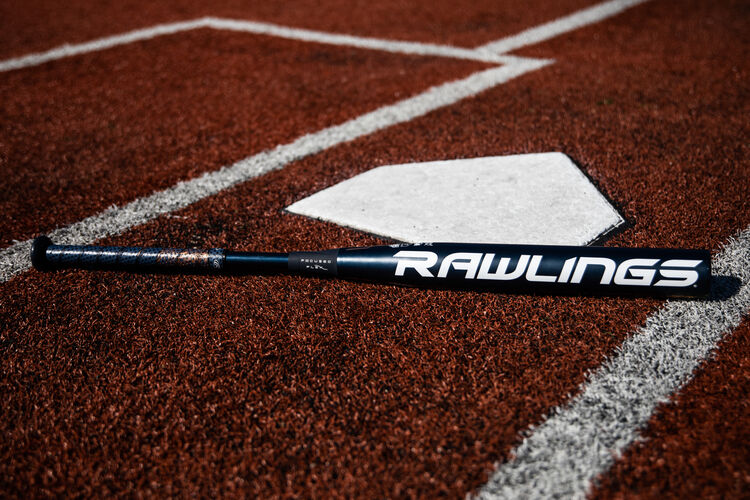A Rawlings fastpitch Quatro Pro bat lying on a field next to home plate - SKU: FPZP9
