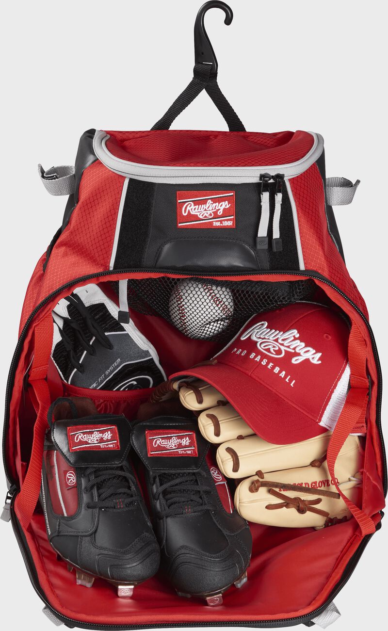 The open main compartment of a VELOBK with cleats, glove, hat, batting gloves and a ball
