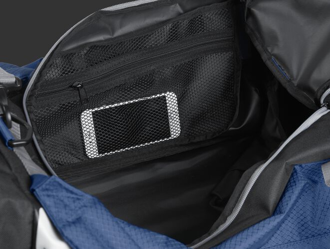 A phone inside the mesh accessory pocket inside the main compartment of a navy R601 Hybrid bag