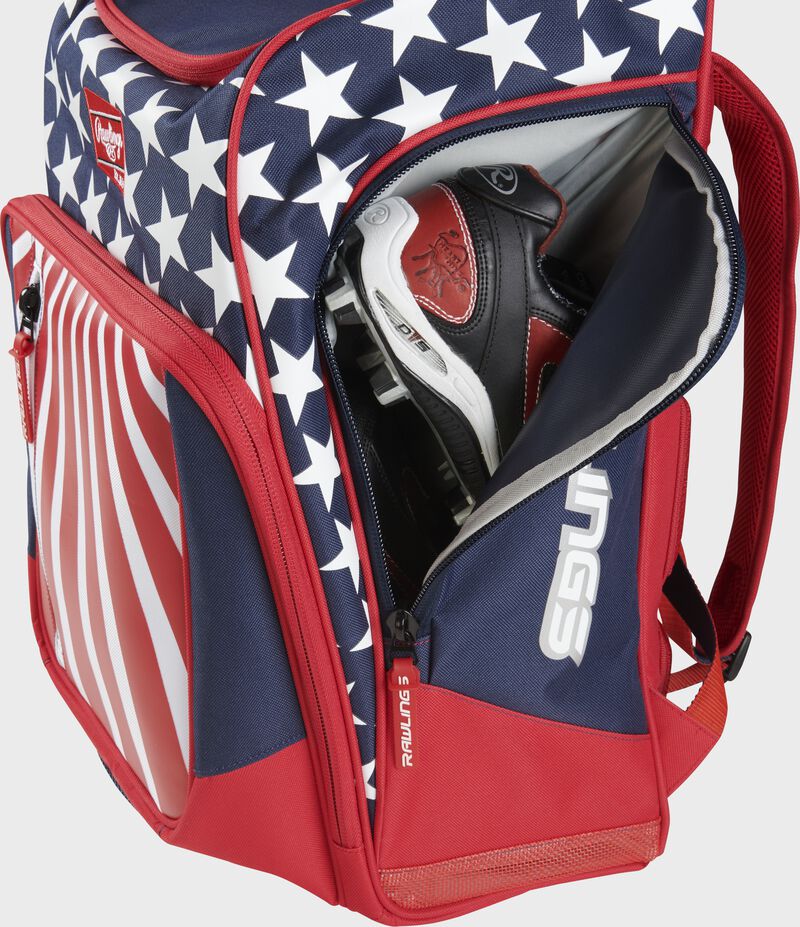 Sie view of red, white, and blue Rawlings Legion Backpack with cleats inside - SKU: LEGION
