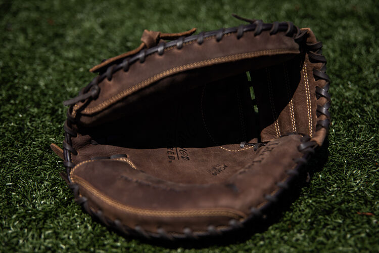 Brown palm of a Player Preferred recreational mitt lying on a field - SKU: PCM30