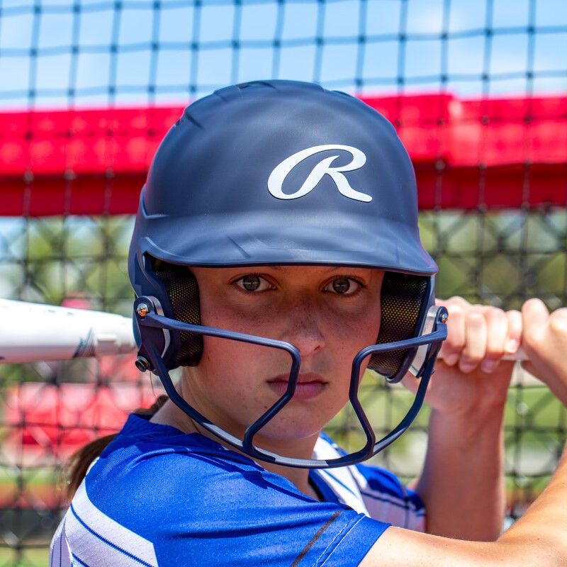 A player holding a bat witha  navy Mach Hi-Viz softball batting helmet - SKU: MCHVIZ loading=
