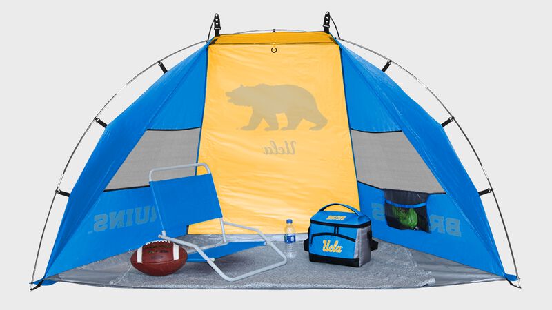 A UCLA Bruins sun shelter with a chair, football and cooler