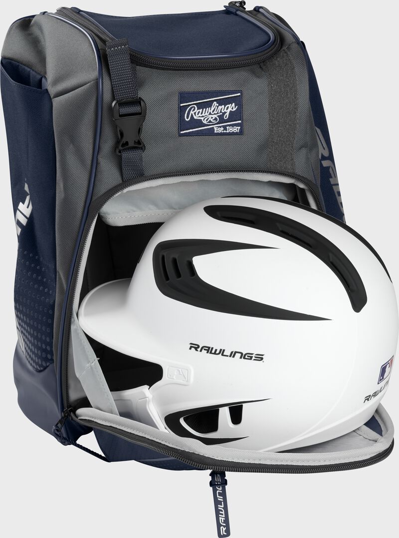 A white/black helmet in the main compartment of a navy Rawlings Franchise backpack - SKU: FRANBP-N