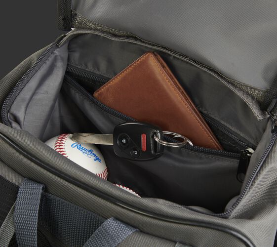 Personal items in the top valet tray pocket of a gray R701 universal training backpack