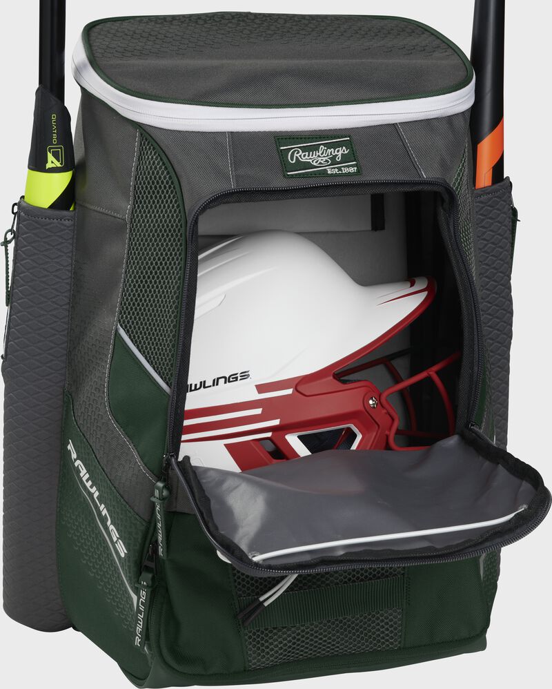 A dark green Impulse baseball backpack with a helmet in the main compartment - SKU: IMPLSE-DG loading=