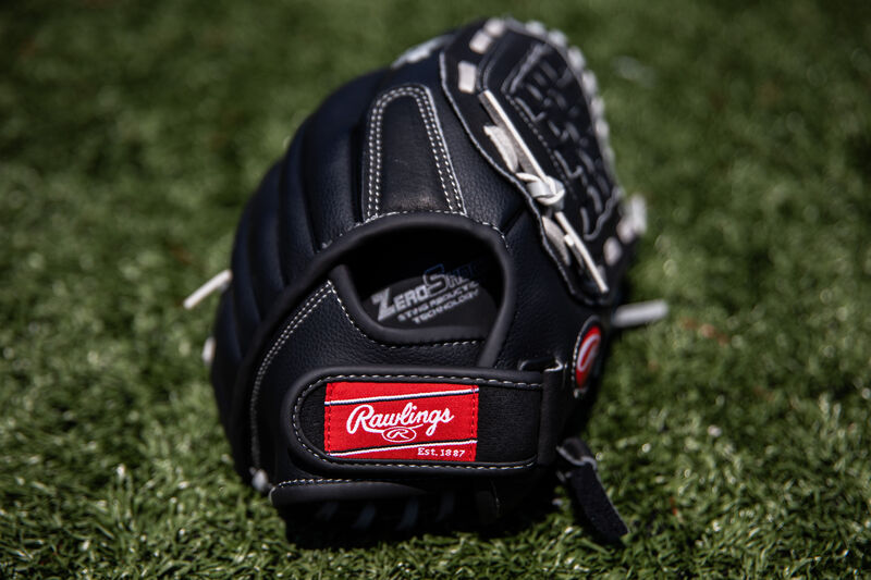 Rawlings patch on the wrist strap of a Rawlings Softball series glove lying on a field - SKU: RSB120GB