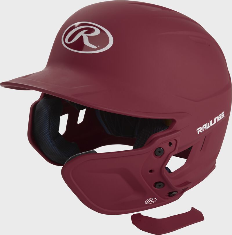 A cardinal MEXTR attached to a Mach batting helmet with the removable TPU piece off to show the hardware