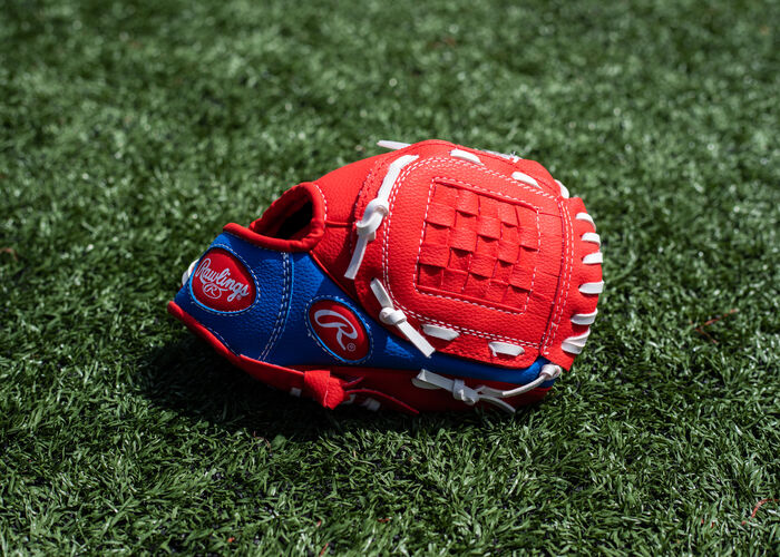 Red Basket Web on a Players Series Basket web glove lying on a field - SKU: PL91SR