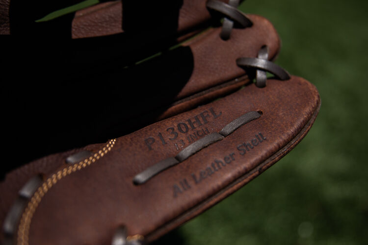Brown pinkie of a Rawlings Player Preferred recreational glove on a field - SKU: P130HFL