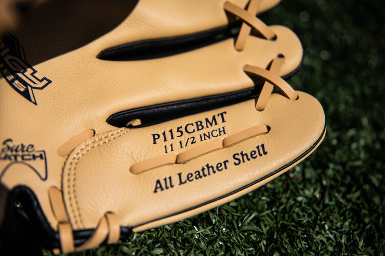 Camel pinkie on a Rawlings Prodigy youth infield glove lying on a field - SKU: P115CBMT