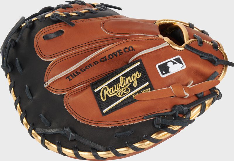 Golden brown back of a Heart of the Hide ColorSync 8.0 34" catcher's mitt with a black/gold Rawlings patch - SKU: PROYM4GBB
