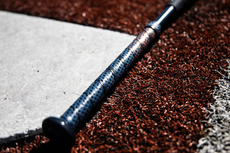 Lizard Skins grip of a Rawlings Quatro Pro fastpitch softball bat lying next to home plate - SKU: FPPE10