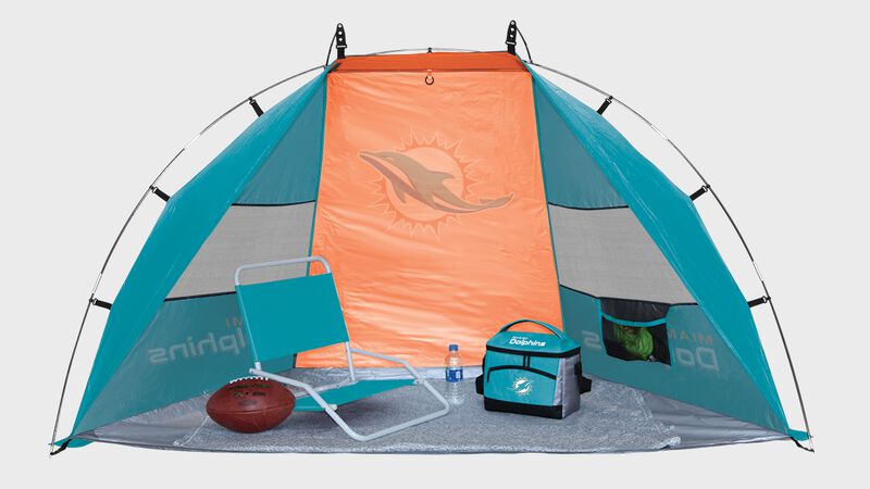 Inside of a Miami Dolphins shelter tent with a chair cooler and ball