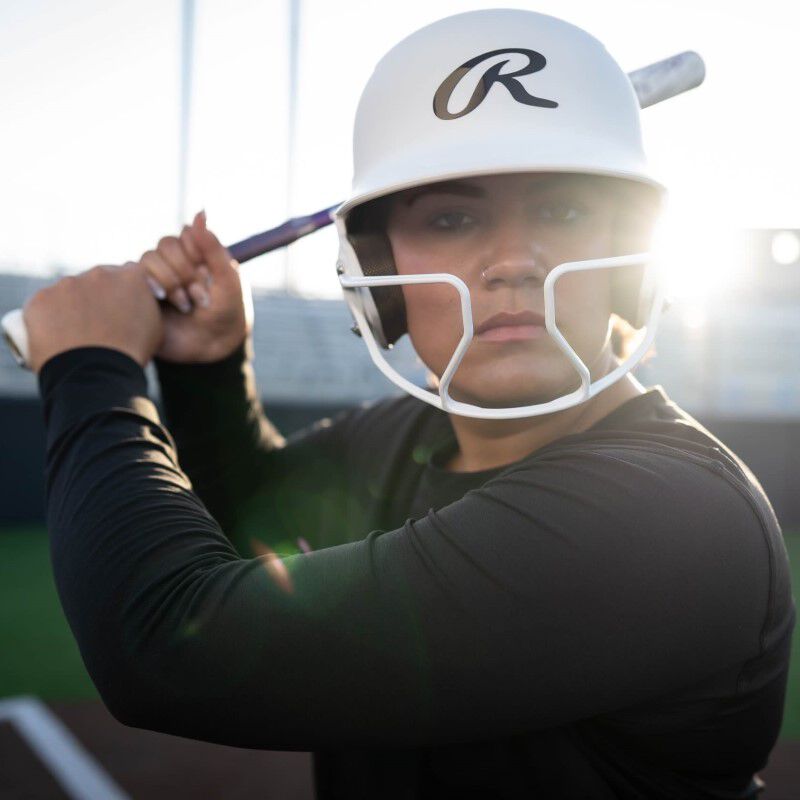Jocelyn Alo holding a bat wearing a white Mach Hi-Viz batting helmet - SKU: MCHVIZ