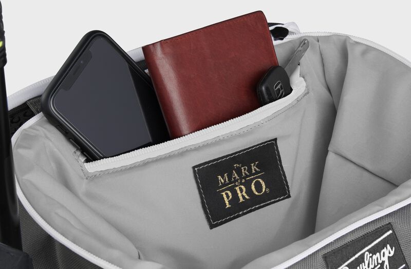 Zippered pocket in the top storage compartment of a black Impulse backpack with a phone, wallet and keys - SKU: IMPLSE-B
