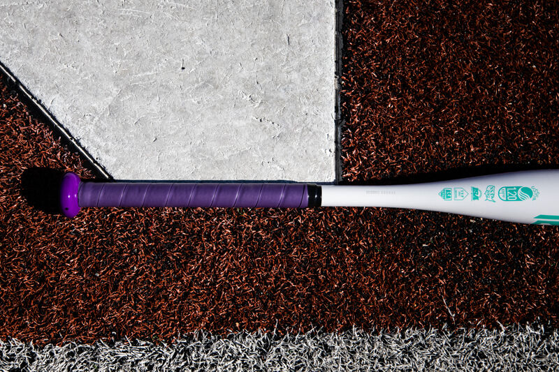 Purple batting grip of a Rawlings Ombre fastpitch bat lying next to home plate - SKU: FPZO11 loading=