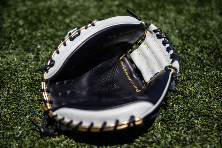 A black palm of a Rawlings Encore catcher's mitt lying on a field - ECCM32-23BW