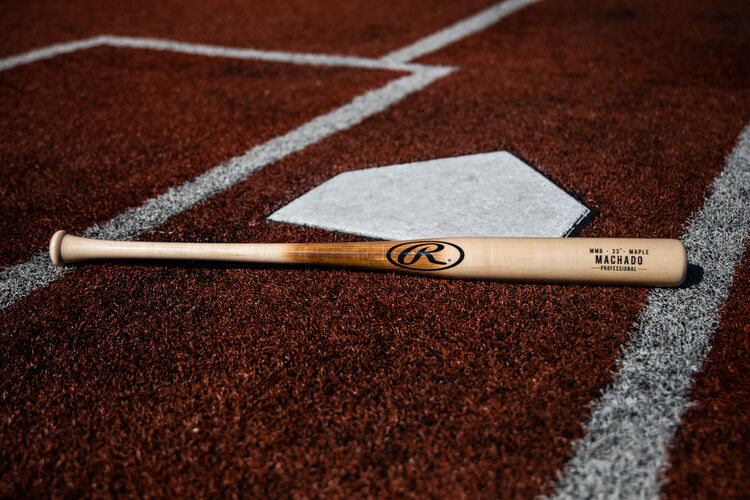 A Rawlings Manny Machado Pro Label bat lying next to home plate - SKU: MM8PL