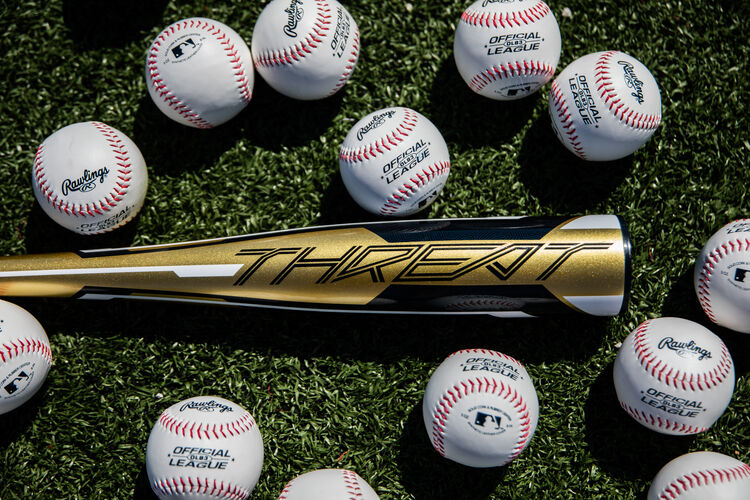 Gold barrel of a -12 Threat USA bat lying on a field with baseballs - SKU: USZT12