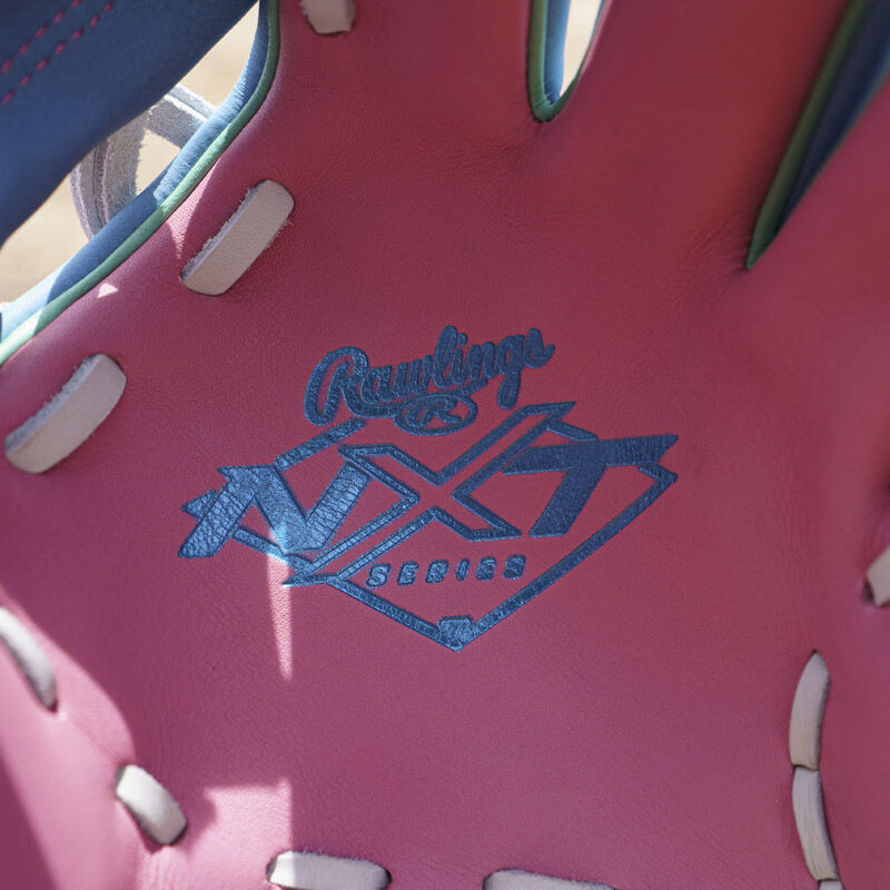 Columbia blue Rawlings NXT series logo stamped on the pink leather palm of an Exclusive Rawlings NXT Series 11.5" Infield Glove
