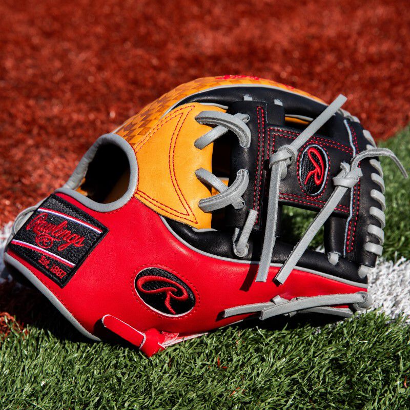 Thumb of a tan/scarlet/black ColorSync 8.0 Heart of the Hide glove on a field