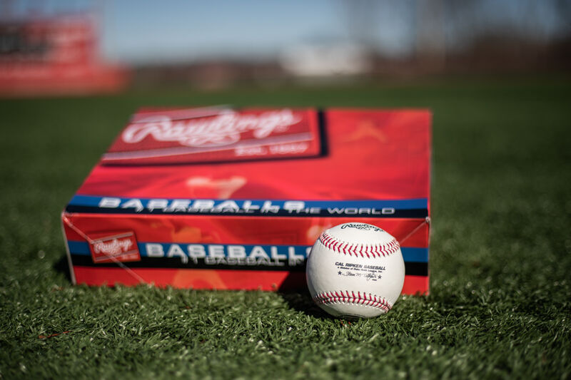 A Cal Ripken baseball lying in front of a ball box on a field - SKU: RCAL1