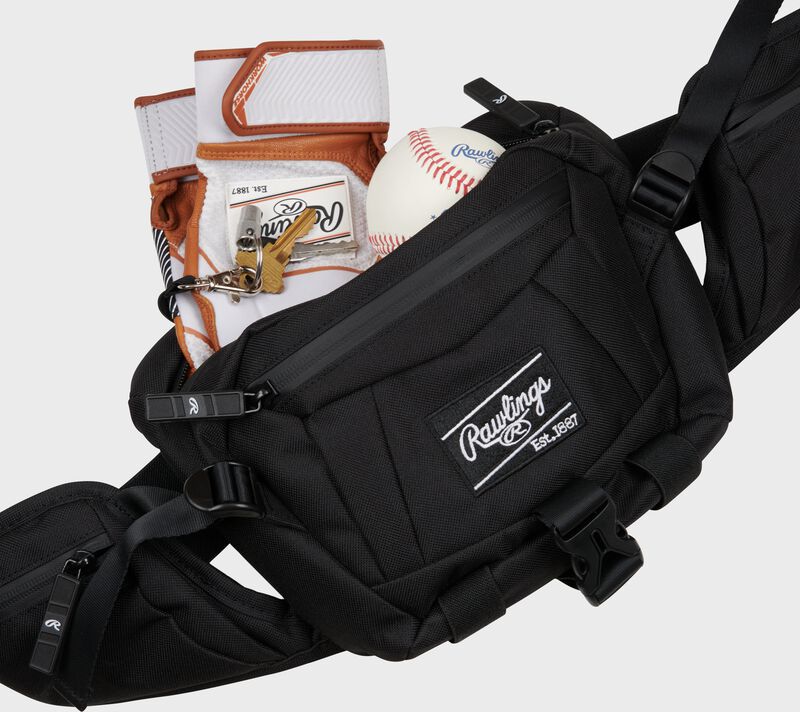 Front of a black Rawlings sling bag with a pair of batting gloves in the main pocket - SKU: RSLING-BK