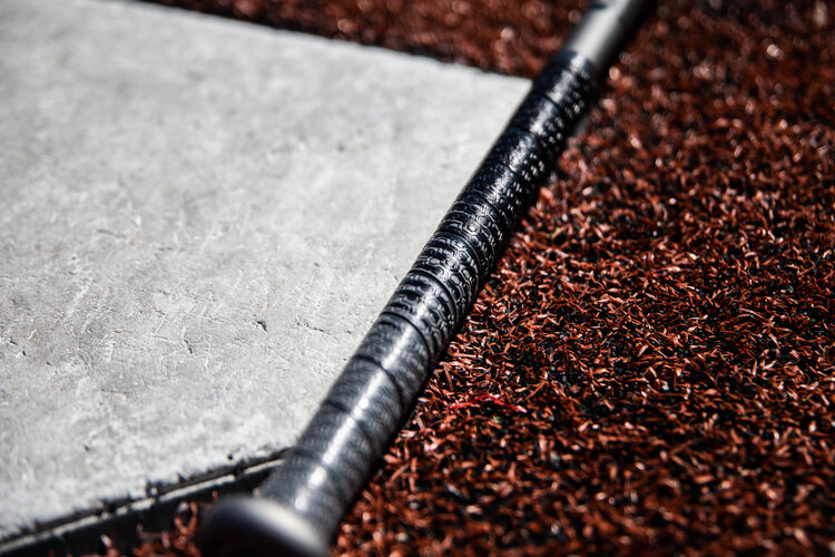 Batting grip on Rawlings Velo ACP USA bat lying next to home plate - SKU: USZV10