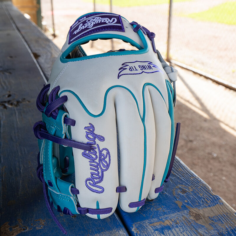 Picture of a white/teal Rawlings exclusive Heart of the Hide R2G Wing Tip 11.5" infield glove standing on its fingertips on a table
