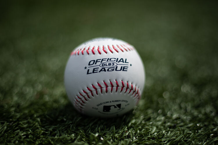 An Official League baseball lying on a field with the MLB logo showing on the bottom - SKU: OLB3