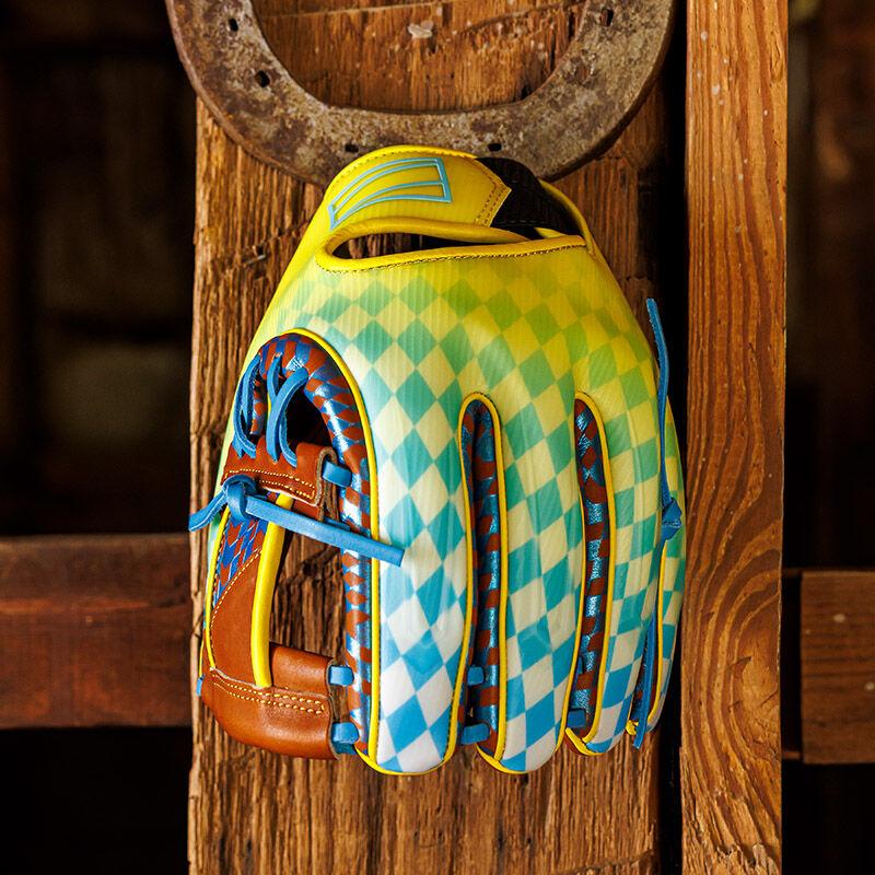 A Rawlings Race Day REV1X infield glove hanging on a wall at a stable