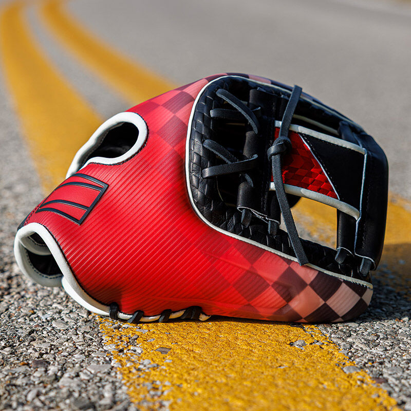 Picture of a Rawlings REV1X Checkered Flag infield glove on the yellow lines of a paved road