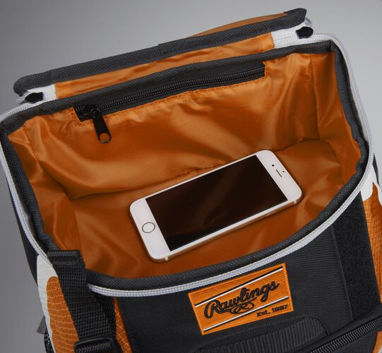 Top accessory pocket of a black/orange R500 equipment backpack holding a phone