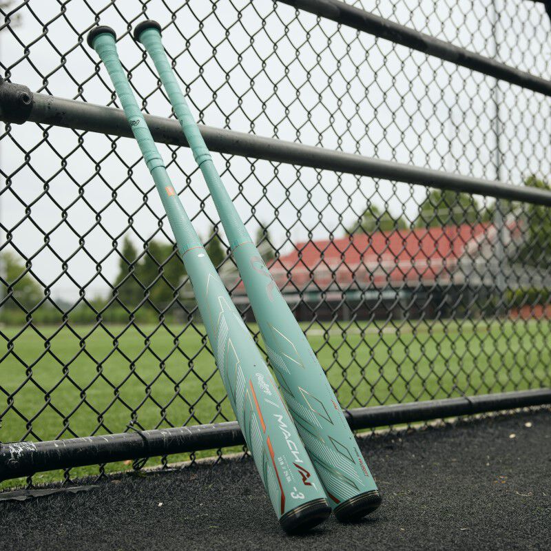 2 ocean mint Rawlings Mach AI bats leaning against a fence - SKU: RBB4MC3