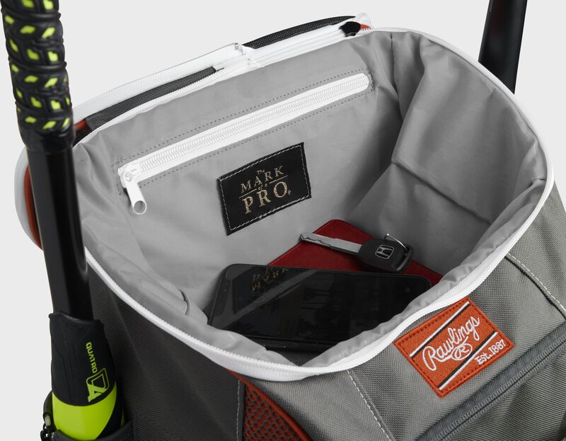 Top compartment of an orange Impulse bag with a phone, keys and black "The Mark of a Pro" patch - SKU: IMPLSE-BO
