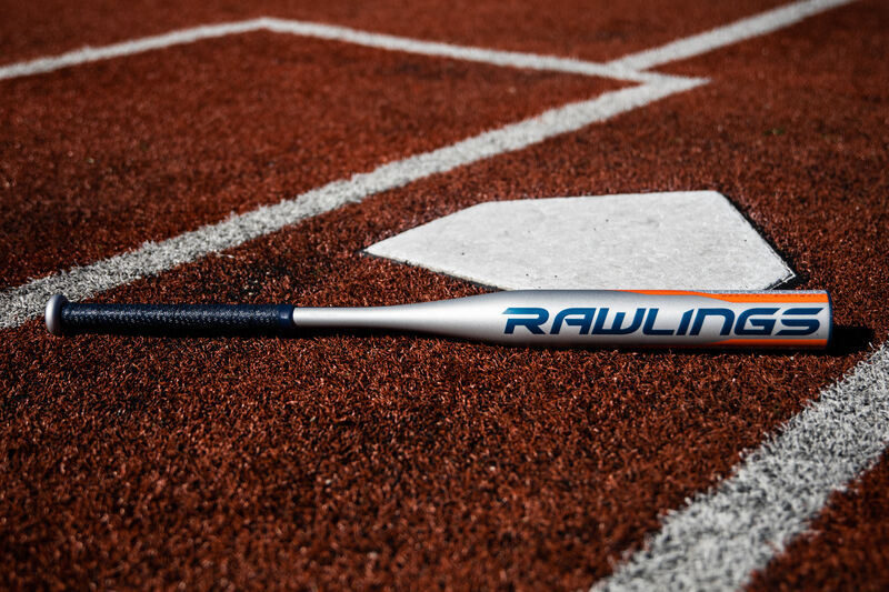 A Rawlings Storm fastpitch bat lying next to home plate - SKU: FPZS13