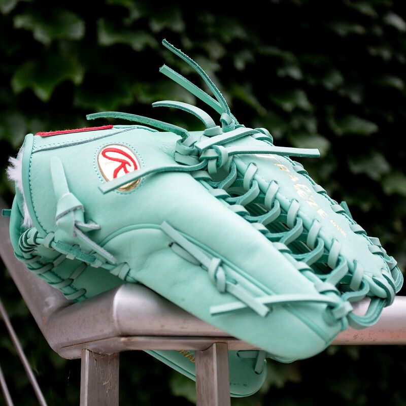 Picture of an ocean mint Gameday 57 Harrison Bader Pro Preferred glove on a hand rail loading=
