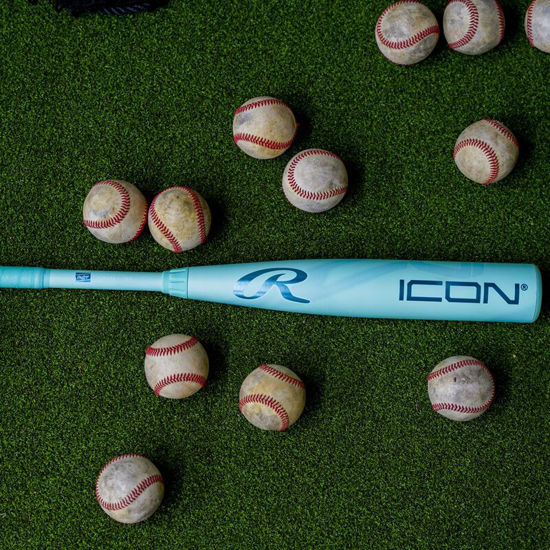A 2026 Rawlings Icon BBCOR bat on the ground surrounded by baseballs