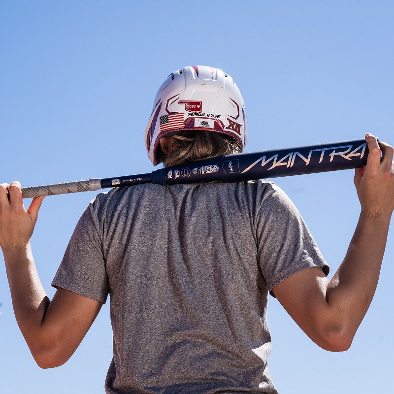 A picture of Kinzie Hansen holding a Mantra bat behind her head